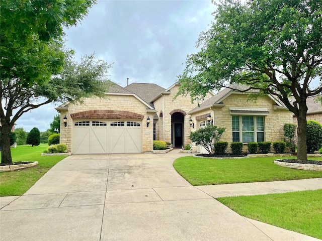 1413 Discovery Bay Dr, Frisco, TX 75036 - french country home with stone siding, a garage, concrete driveway, a front yard, and a shingled roof