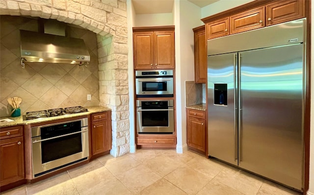1413 Discovery Bay Dr, Frisco, TX 75036 - kitchen with appliances with stainless steel finishes, wall chimney range hood, tasteful backsplash, and light stone countertops
