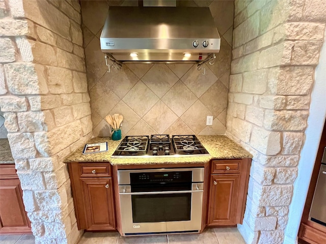 1413 Discovery Bay Dr, Frisco, TX 75036 - kitchen with stainless steel appliances, extractor fan, light stone countertops, and brown cabinetry