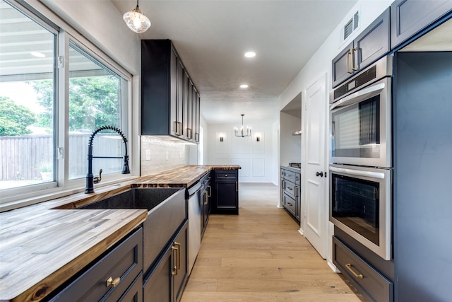 2955 Las Campanas Dr, Farmers Branch, TX 75234 - kitchen with wooden counters, stainless steel appliances, a chandelier, healthy amount of natural light, and recessed lighting