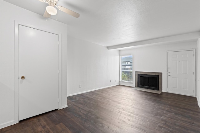5500 Boca Raton Blvd Unit 327, Fort Worth, TX 76112 - unfurnished living room featuring dark wood-style flooring, a fireplace, a ceiling fan, and a textured ceiling