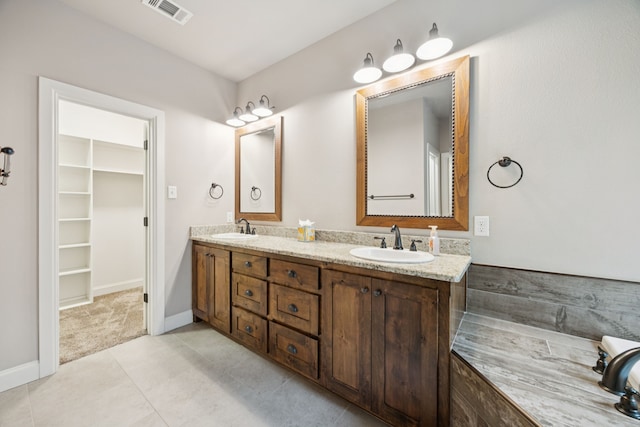 149 Ty Ln, Azle, TX 76020 - bathroom featuring double vanity, a walk in closet, and tile patterned flooring