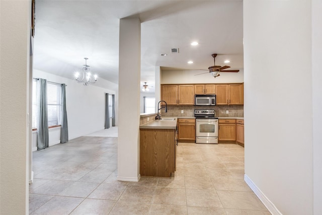 205 Bear Trl, Waxahachie, TX 75165 - kitchen featuring appliances with stainless steel finishes, a chandelier, ceiling fan, decorative backsplash, and light tile patterned flooring