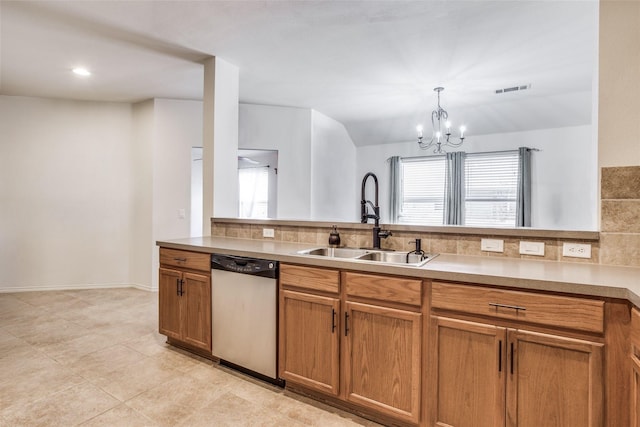 205 Bear Trl, Waxahachie, TX 75165 - kitchen featuring stainless steel dishwasher, brown cabinets, a chandelier, and decorative backsplash
