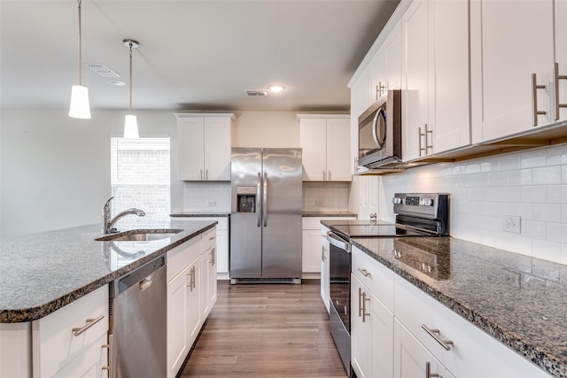 721 Brockwell Bnd, Forney, TX 75126 - kitchen with stainless steel appliances, white cabinetry, dark stone counters, tasteful backsplash, and recessed lighting