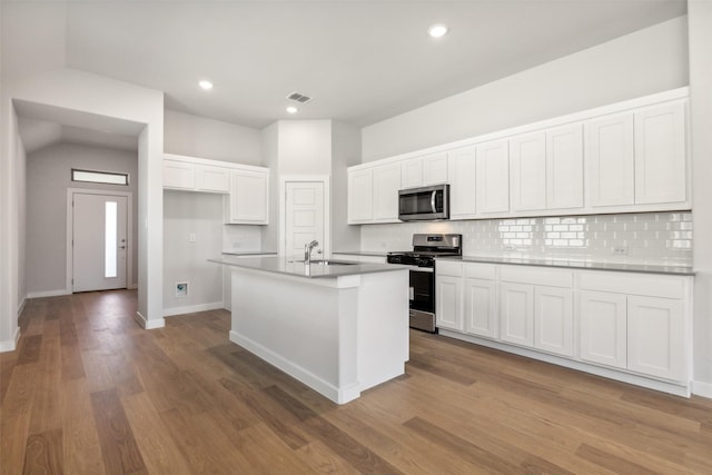 923 Hazel Dr, Lavon, TX 75166 - kitchen with stainless steel appliances, decorative backsplash, white cabinets, a kitchen island with sink, and dark wood-type flooring