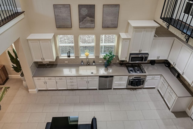 354 Loma Alta Dr, Flower Mound, TX 75022 - kitchen with stainless steel appliances, white cabinetry, light countertops, and tasteful backsplash