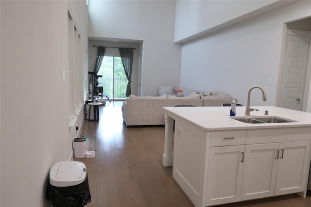 8327 Nunley Ln, Dallas, TX 75231 - kitchen with white cabinetry, dark wood finished floors, a high ceiling, light countertops, and open floor plan