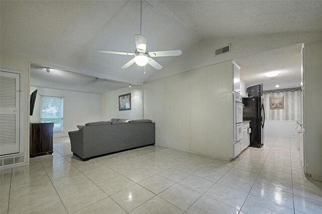 1803 Windsor Dr, Arlington, TX 76012 - living area featuring ceiling fan, a textured ceiling, light tile patterned flooring, and vaulted ceiling