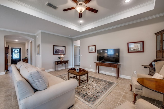 8031 Reservoir Dr, Frisco, TX 75036 - living room featuring arched walkways, a ceiling fan, ornamental molding, a raised ceiling, and light tile patterned flooring