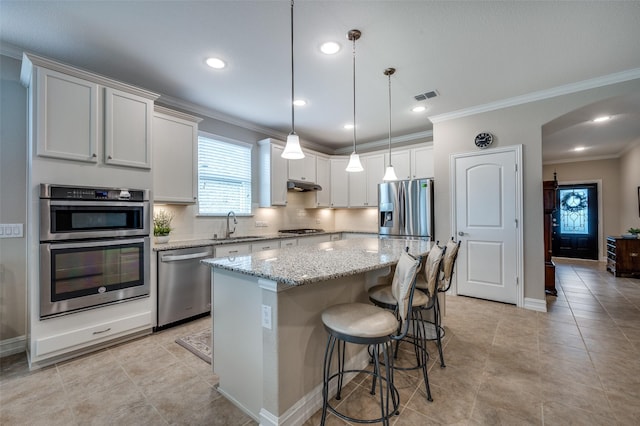 8031 Reservoir Dr, Frisco, TX 75036 - kitchen featuring stainless steel appliances, a kitchen island, arched walkways, crown molding, and backsplash