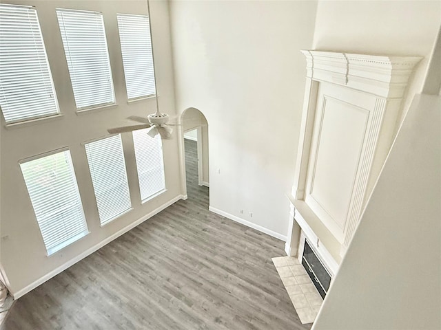 14641 Turnbridge Dr, Frisco, TX 75035 - unfurnished living room with a towering ceiling, a ceiling fan, a fireplace, and dark wood finished floors
