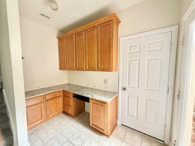 14641 Turnbridge Dr, Frisco, TX 75035 - kitchen featuring built in study area, light tile patterned flooring, and light stone counters