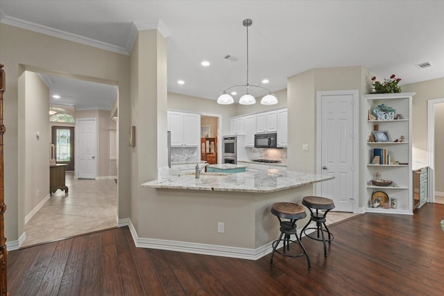3102 Hidden Springs Dr, Corinth, TX 76210 - kitchen featuring black appliances, a peninsula, dark wood-type flooring, white cabinets, and light stone counters