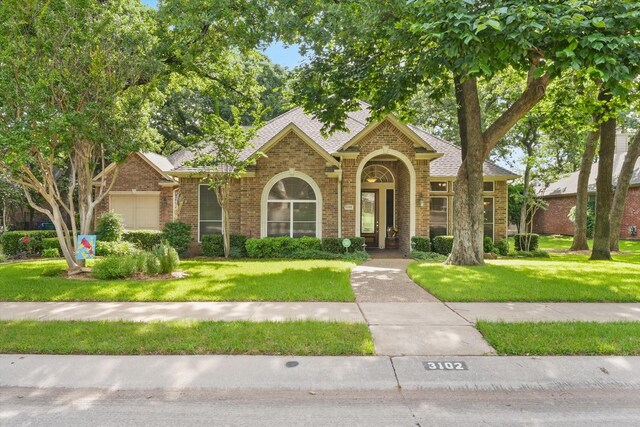 3102 Hidden Springs Dr, Corinth, TX 76210 - view of front of house with brick siding, a front lawn, and roof with shingles
