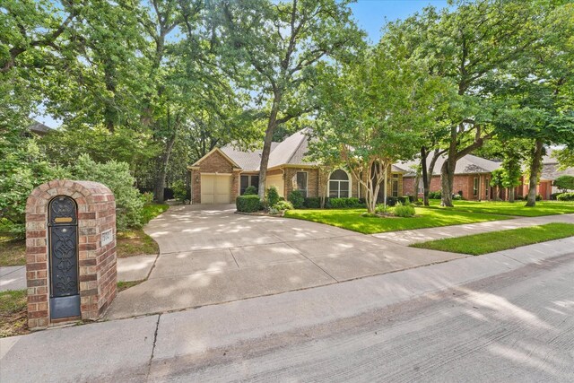 3102 Hidden Springs Dr, Corinth, TX 76210 - view of front of house with driveway, a front yard, an attached garage, and brick siding