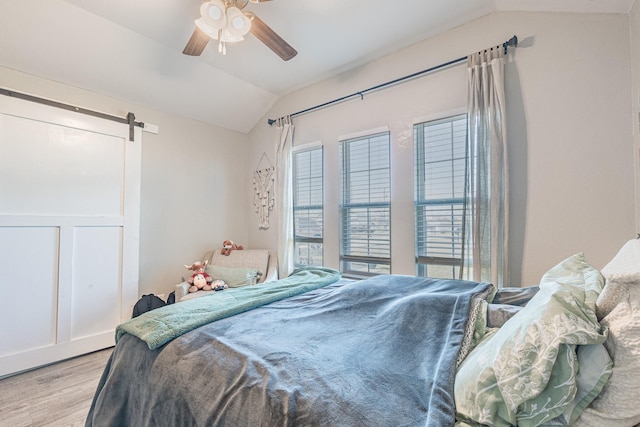 656 Bunk House Dr, Venus, TX 76084 - bedroom with lofted ceiling, wood finished floors, a barn door, and a ceiling fan
