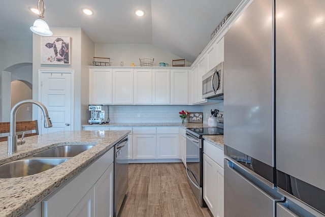 656 Bunk House Dr, Venus, TX 76084 - kitchen with appliances with stainless steel finishes, vaulted ceiling, white cabinetry, light wood-type flooring, and decorative light fixtures