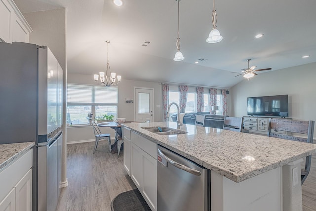 656 Bunk House Dr, Venus, TX 76084 - kitchen with stainless steel appliances, vaulted ceiling, light wood-style floors, white cabinetry, and an island with sink