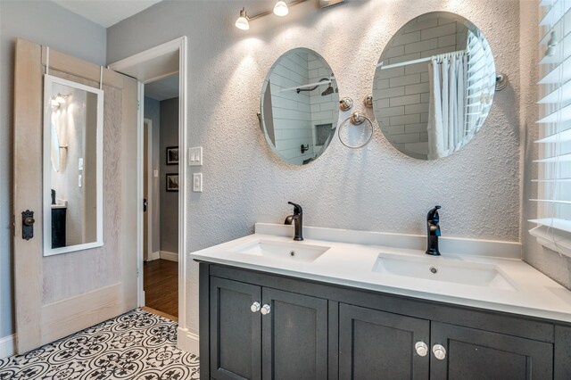 6201 Reiger Ave, Dallas, TX 75214 - bathroom featuring double vanity, tile patterned flooring, and a shower with shower curtain