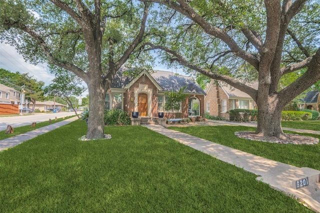 6201 Reiger Ave, Dallas, TX 75214 - english style home featuring brick siding, a front lawn, and roof with shingles