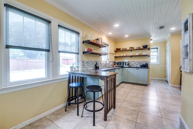 6201 Reiger Ave, Dallas, TX 75214 - kitchen with open shelves, dark countertops, crown molding, recessed lighting, and stainless steel microwave