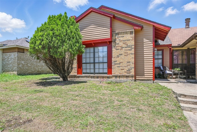 2415 Sunflower Dr, Arlington, TX 76014 - view of property exterior with a lawn, a patio area, and brick siding