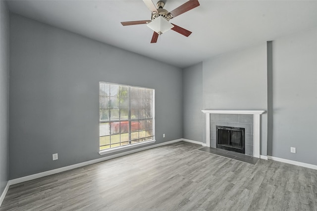 2415 Sunflower Dr, Arlington, TX 76014 - unfurnished living room with wood finished floors, a tiled fireplace, and a ceiling fan