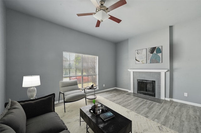 2415 Sunflower Dr, Arlington, TX 76014 - living area with wood finished floors, a tiled fireplace, and ceiling fan