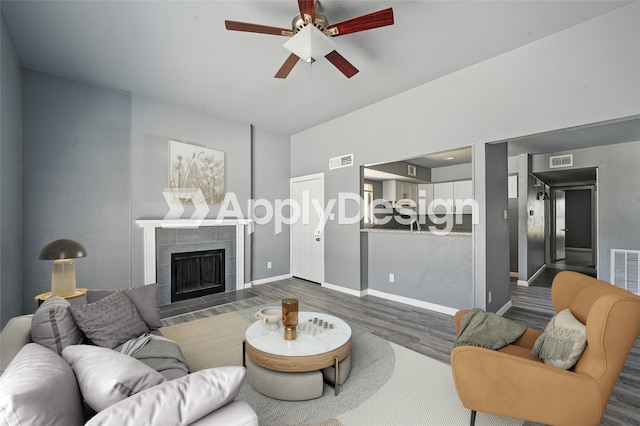 2415 Sunflower Dr, Arlington, TX 76014 - living room featuring wood finished floors, a ceiling fan, and a fireplace