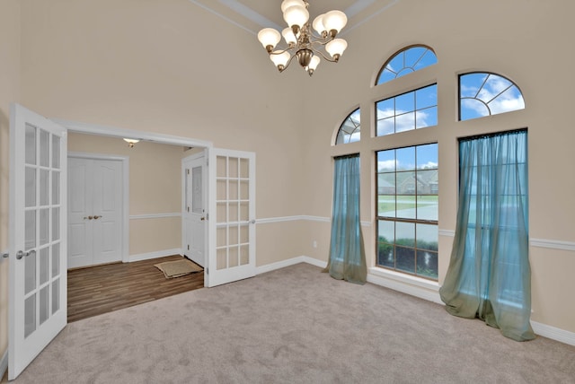 9841 Freedoms Way, Keithville, LA 71047 - carpeted spare room with french doors, a chandelier, healthy amount of natural light, and a towering ceiling