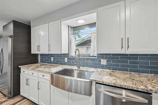 8434 Sweetwood Dr, Dallas, TX 75228 - kitchen featuring appliances with stainless steel finishes, white cabinets, tasteful backsplash, and light stone counters