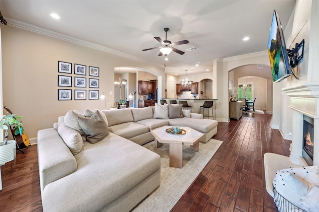 5048 Exposition Way, Fort Worth, TX 76244 - living area with arched walkways, a chandelier, a ceiling fan, ornamental molding, and dark wood-style flooring