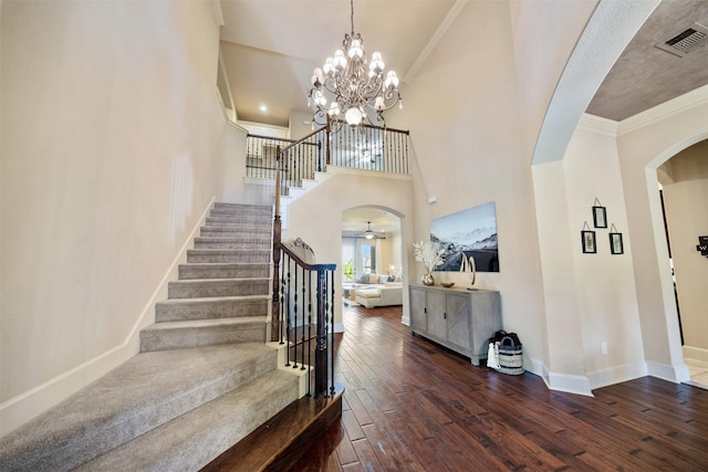 5048 Exposition Way, Fort Worth, TX 76244 - staircase featuring arched walkways, hardwood / wood-style floors, a towering ceiling, ornamental molding, and a chandelier