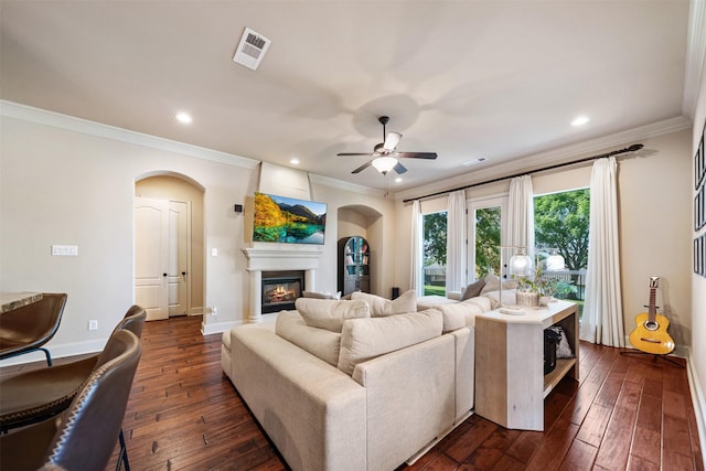 5048 Exposition Way, Fort Worth, TX 76244 - living area with arched walkways, dark wood finished floors, crown molding, a glass covered fireplace, and ceiling fan