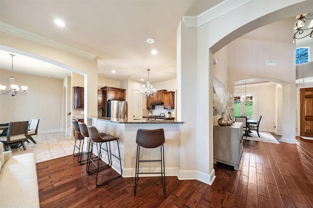5048 Exposition Way, Fort Worth, TX 76244 - kitchen featuring a chandelier, freestanding refrigerator, dark wood-style flooring, a breakfast bar, and dark stone countertops