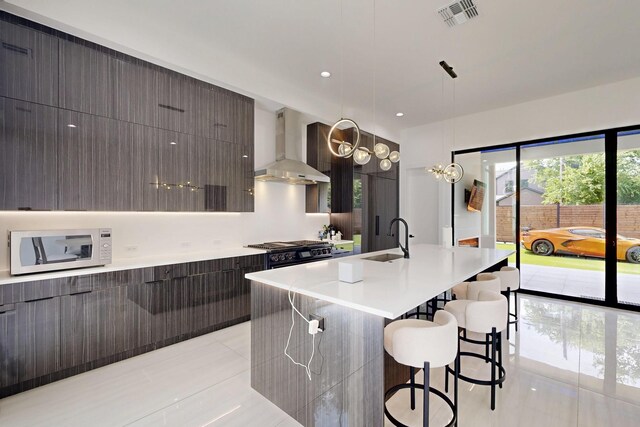 3828 Eaton Dr, Dallas, TX 75220 - kitchen with wall chimney exhaust hood, modern cabinets, white microwave, and light tile patterned floors