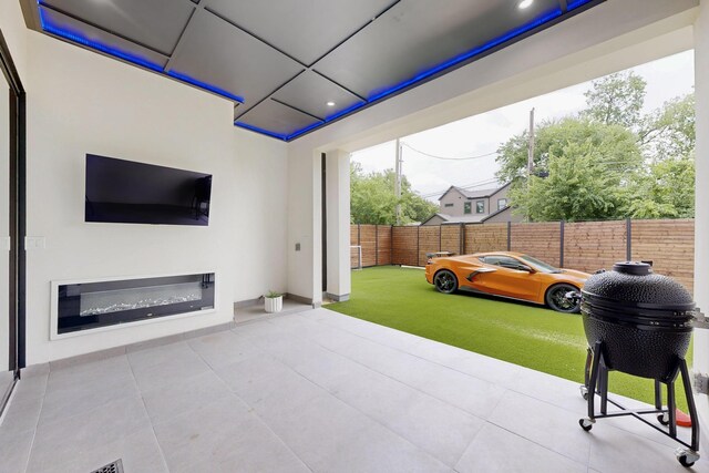3828 Eaton Dr, Dallas, TX 75220 - fenced backyard featuring a patio area and a glass covered fireplace
