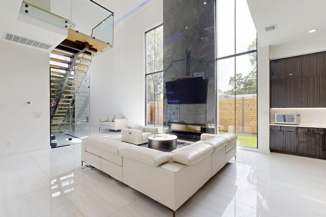 3828 Eaton Dr, Dallas, TX 75220 - living room with light tile patterned flooring, stairway, and plenty of natural light