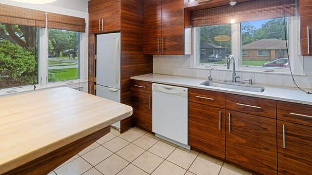10150 Eastwood Dr, Dallas, TX 75228 - kitchen with white appliances, modern cabinets, light countertops, light tile patterned flooring, and backsplash