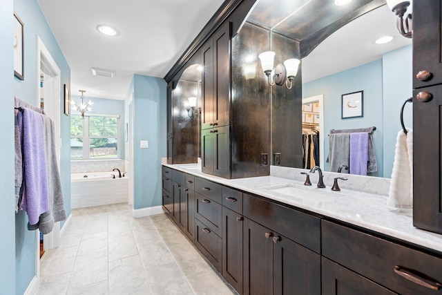 8928 Aldwick Cir, Dallas, TX 75238 - full bath featuring a chandelier, a bath, double vanity, marble look tiles, and recessed lighting