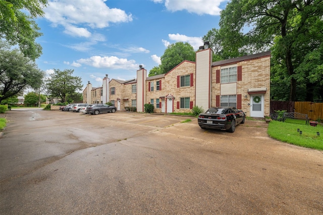 123 Austin Stone Dr, Duncanville, TX 75137 - view of front facade with uncovered parking, brick siding, a residential view, and a chimney