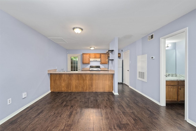 123 Austin Stone Dr, Duncanville, TX 75137 - kitchen with range, dark wood finished floors, under cabinet range hood, freestanding refrigerator, and brown cabinetry