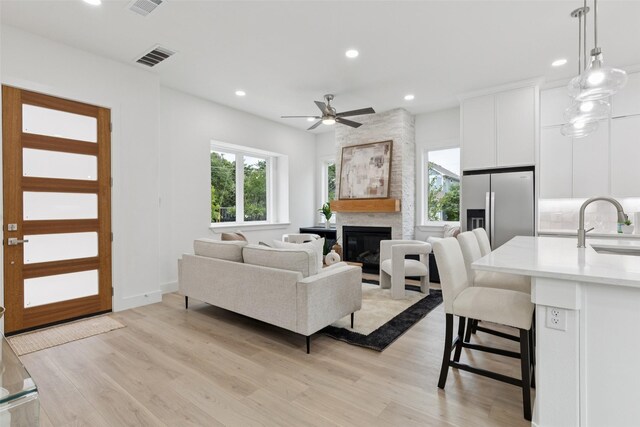 1000 W 10th St, Dallas, TX 75208 - living area with light wood finished floors, recessed lighting, a large fireplace, and a ceiling fan