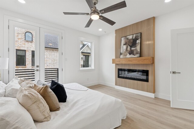 1000 W 10th St, Dallas, TX 75208 - bedroom featuring a glass covered fireplace, access to outside, light wood-type flooring, recessed lighting, and a ceiling fan