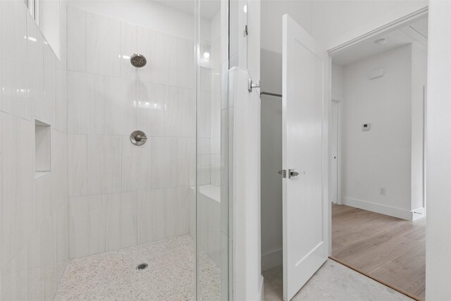 1000 W 10th St, Dallas, TX 75208 - bathroom featuring tiled shower and wood finished floors