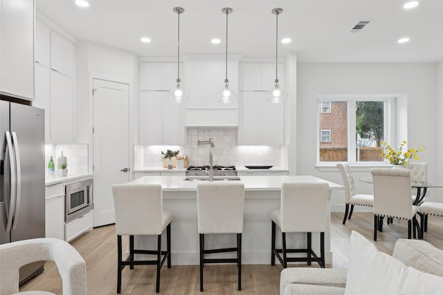 1000 W 10th St, Dallas, TX 75208 - kitchen with appliances with stainless steel finishes, a kitchen breakfast bar, backsplash, and recessed lighting