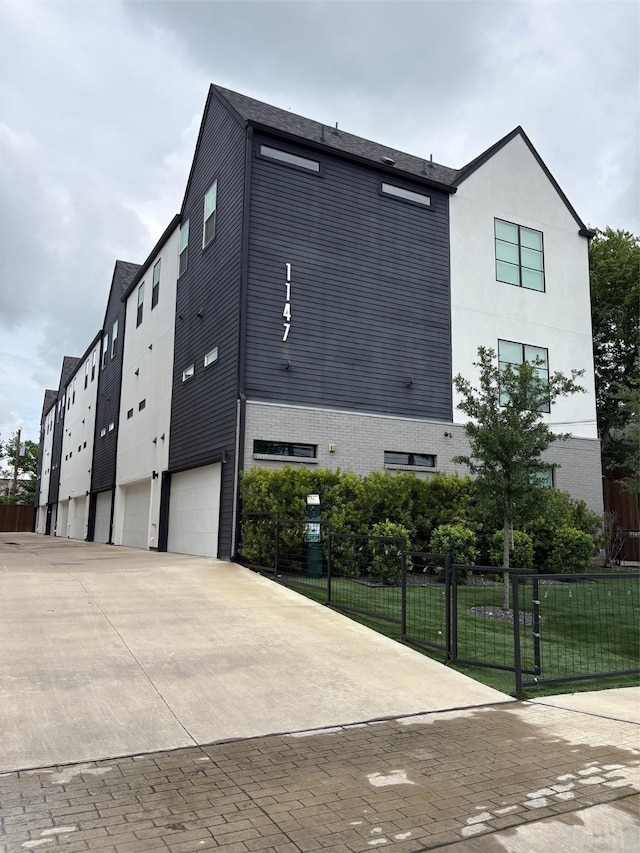 1147 N Madison Ave Unit 102, Dallas, TX 75208 - view of property with a garage and concrete driveway