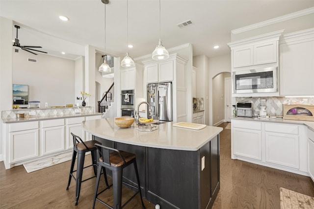 1330 Heavenly Pl, Wylie, TX 75098 - kitchen featuring stainless steel appliances, dark wood-type flooring, light countertops, tasteful backsplash, and a center island with sink