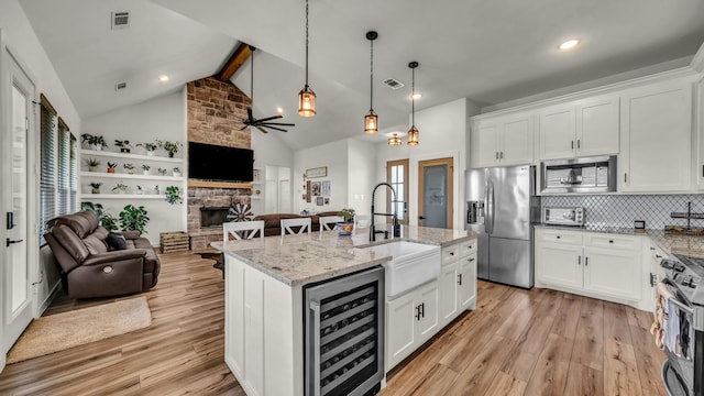 1401 County Road 1470, Chico, TX 76431 - kitchen featuring wine cooler, stainless steel appliances, open floor plan, light wood-type flooring, and beam ceiling